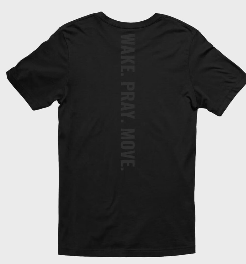 Black t-shirt with “WAKE. PRAY. MOVE.” printed vertically down the spine in dark gray block letters.
