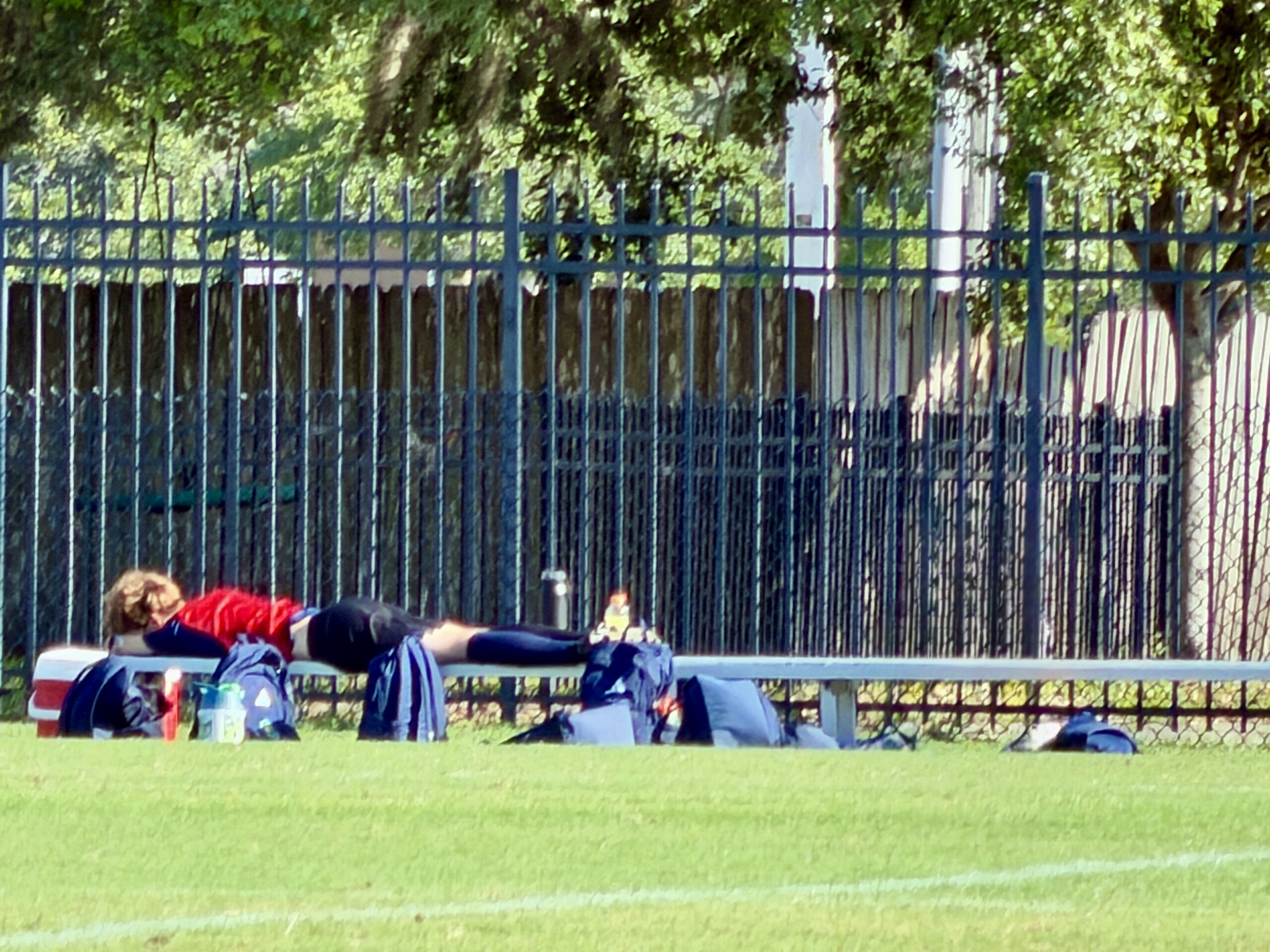 Teaching kids responsibility through sports as a young soccer player rests on the bench during a tournament after playing while sick